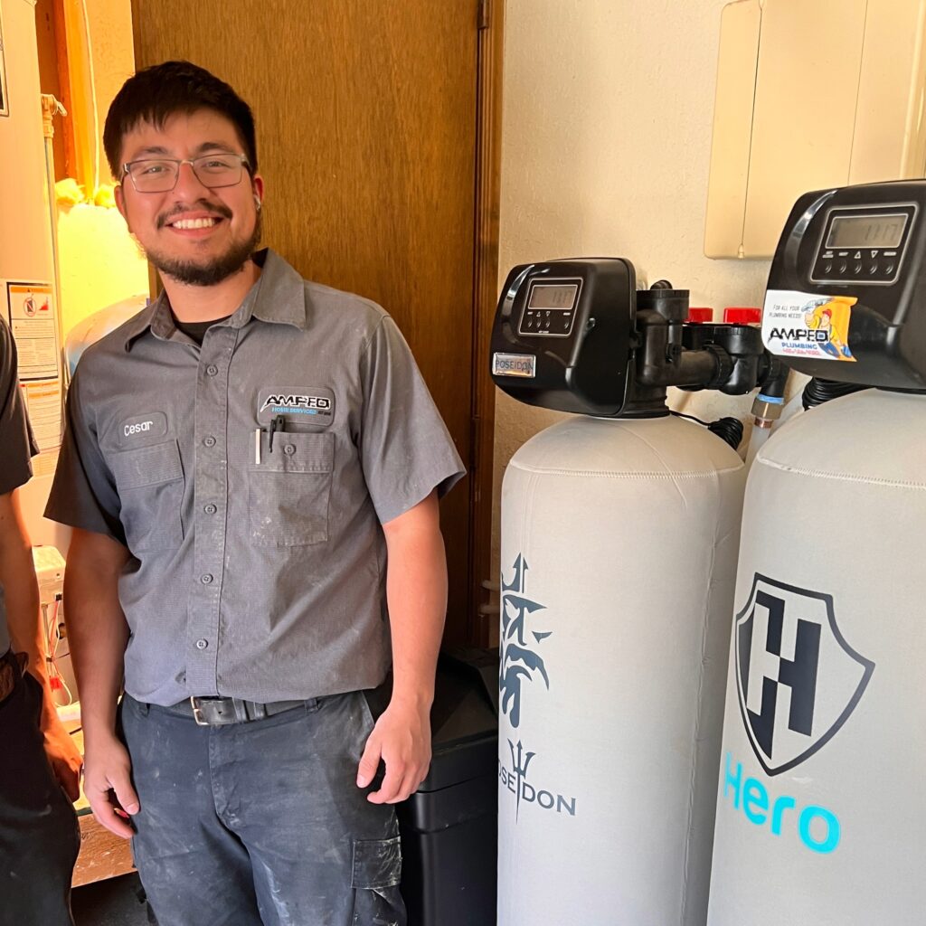 Amped plumber servicing residential water treatment system in Oklahoma.