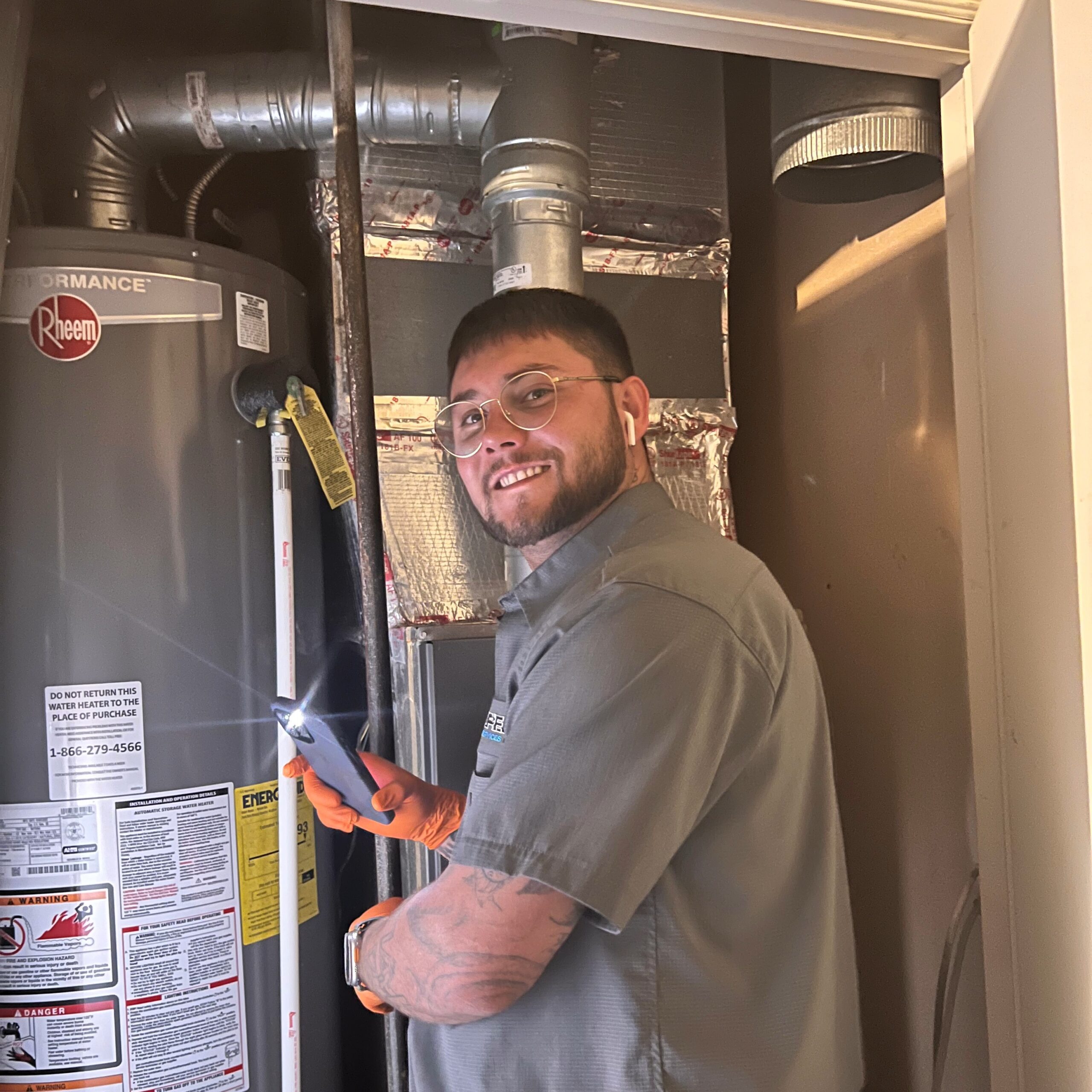 Amped plumber servicing gas water heater in Oklahoma.