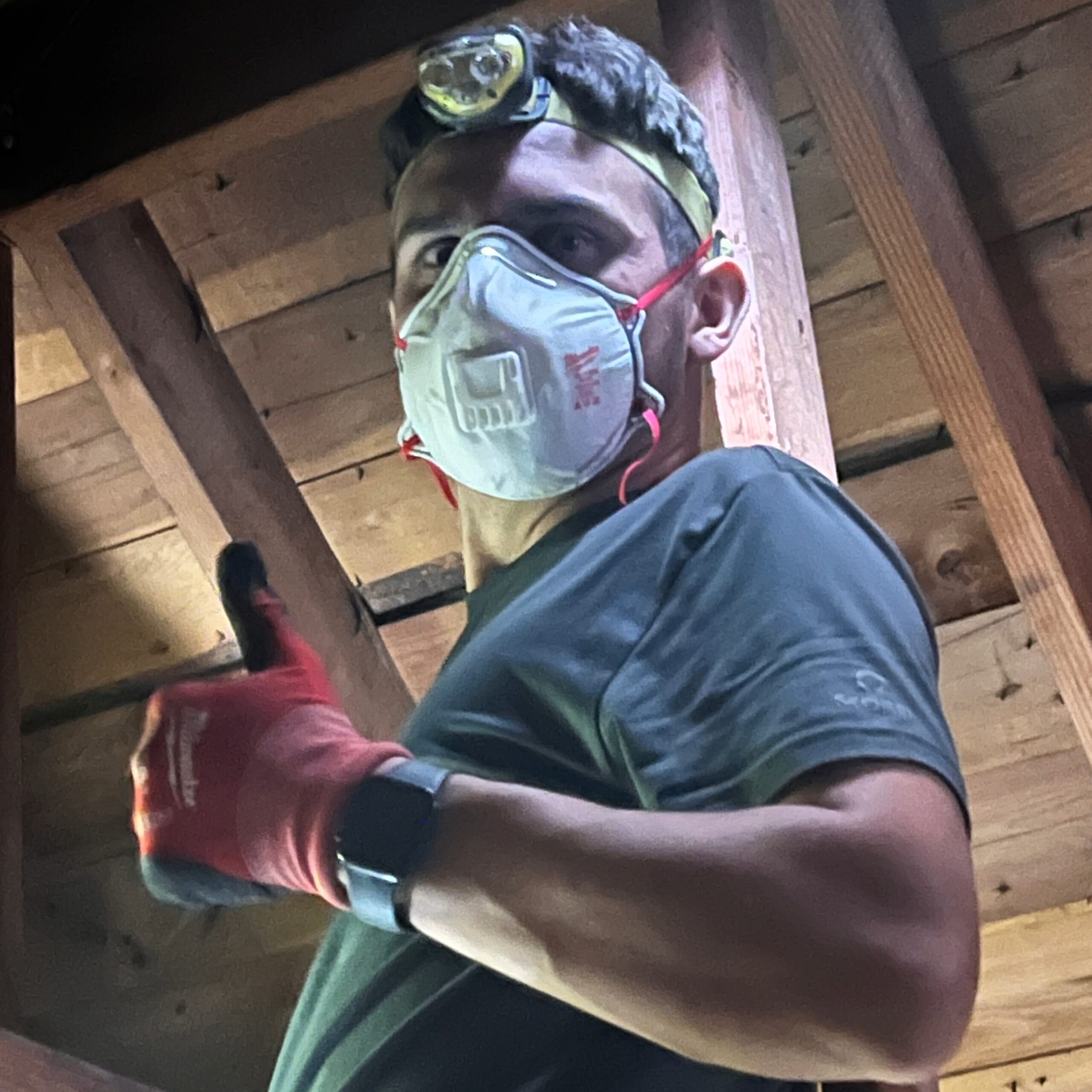 Amped HVAC technician inspecting attic space in Oklahoma.
