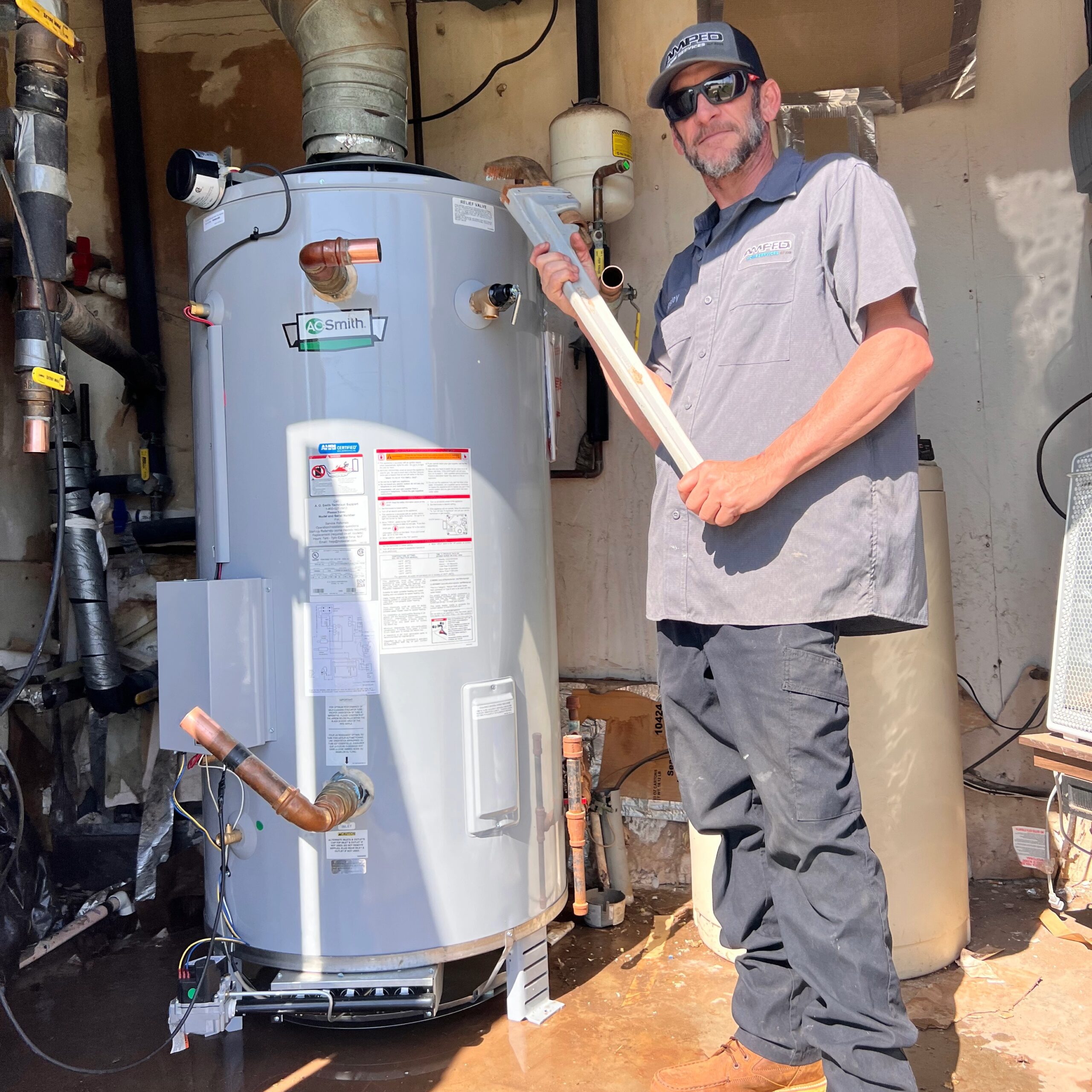 Amped plumber inspecting residential water heater in Oklahoma.