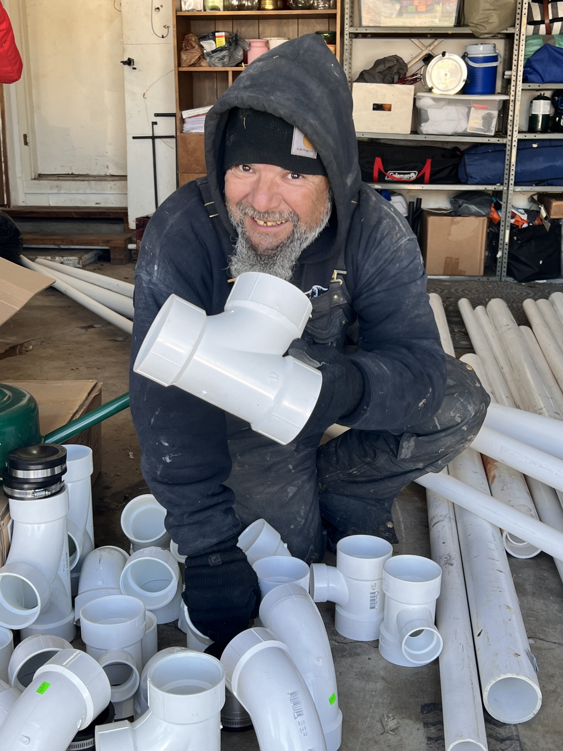 Amped plumber organizing PVC fittings for installation in Oklahoma.
