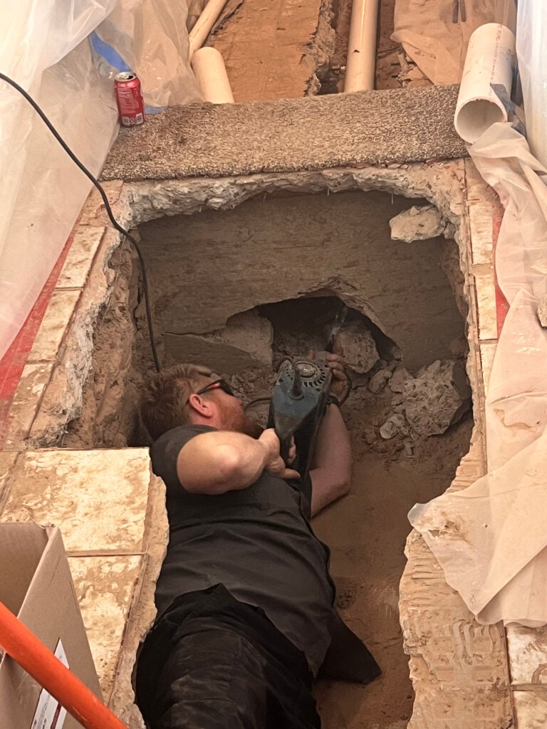 Amped plumber repairing underground plumbing in Oklahoma.