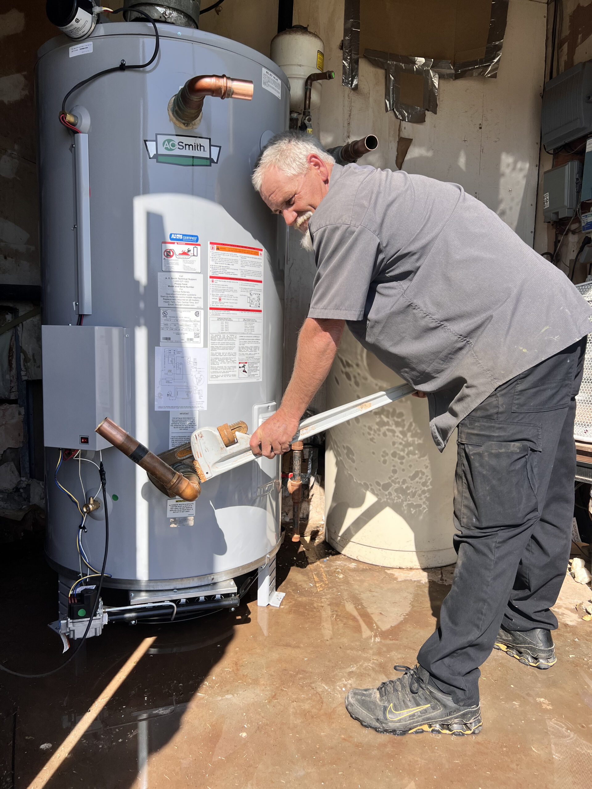 Amped plumber performing water heater maintenance in Oklahoma.
