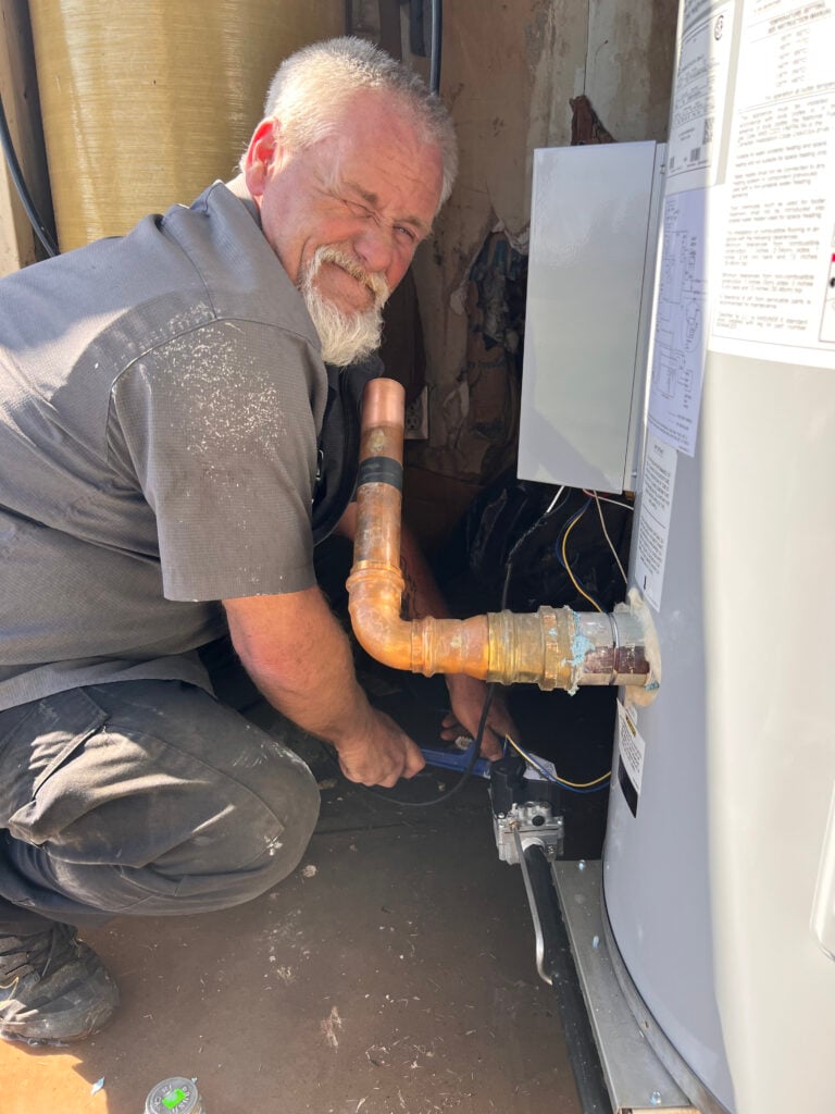 Amped plumber repairing corroded pipes in Oklahoma.