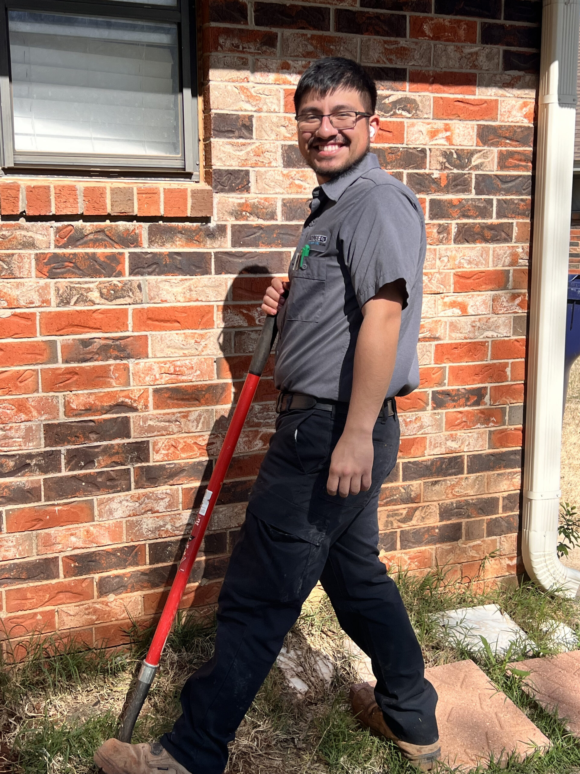 Amped plumber preparing for outdoor plumbing repair in Oklahoma.