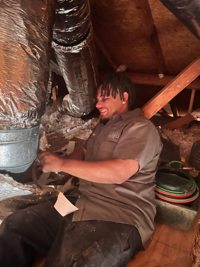 Amped technician working in crawl space HVAC duct system in Oklahoma.