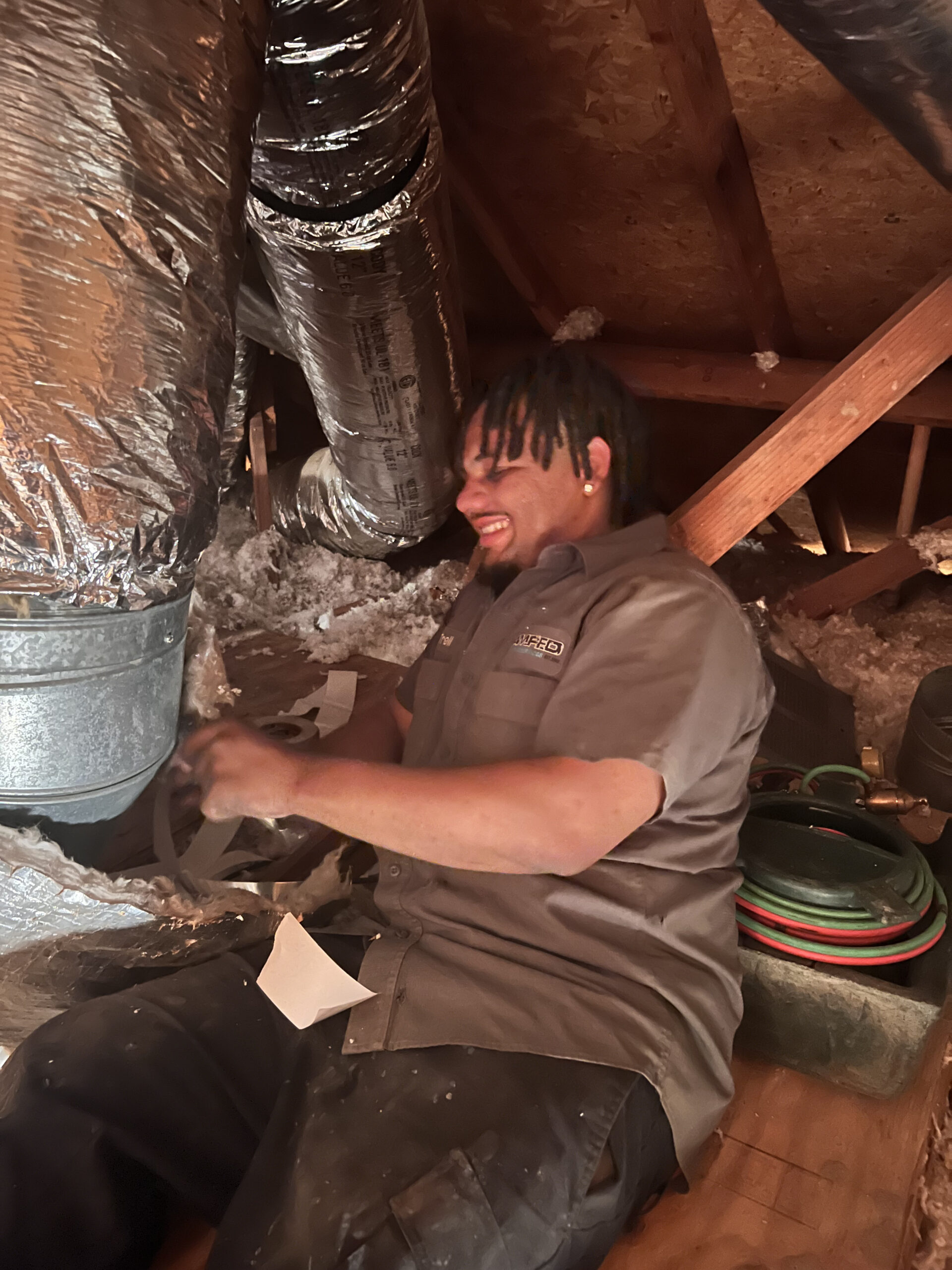 Amped technician working in crawl space HVAC duct system in Oklahoma.