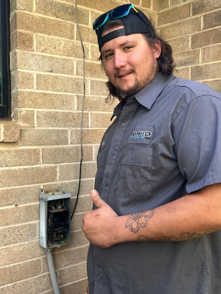 Amped technician inspecting outdoor utility box in Oklahoma.