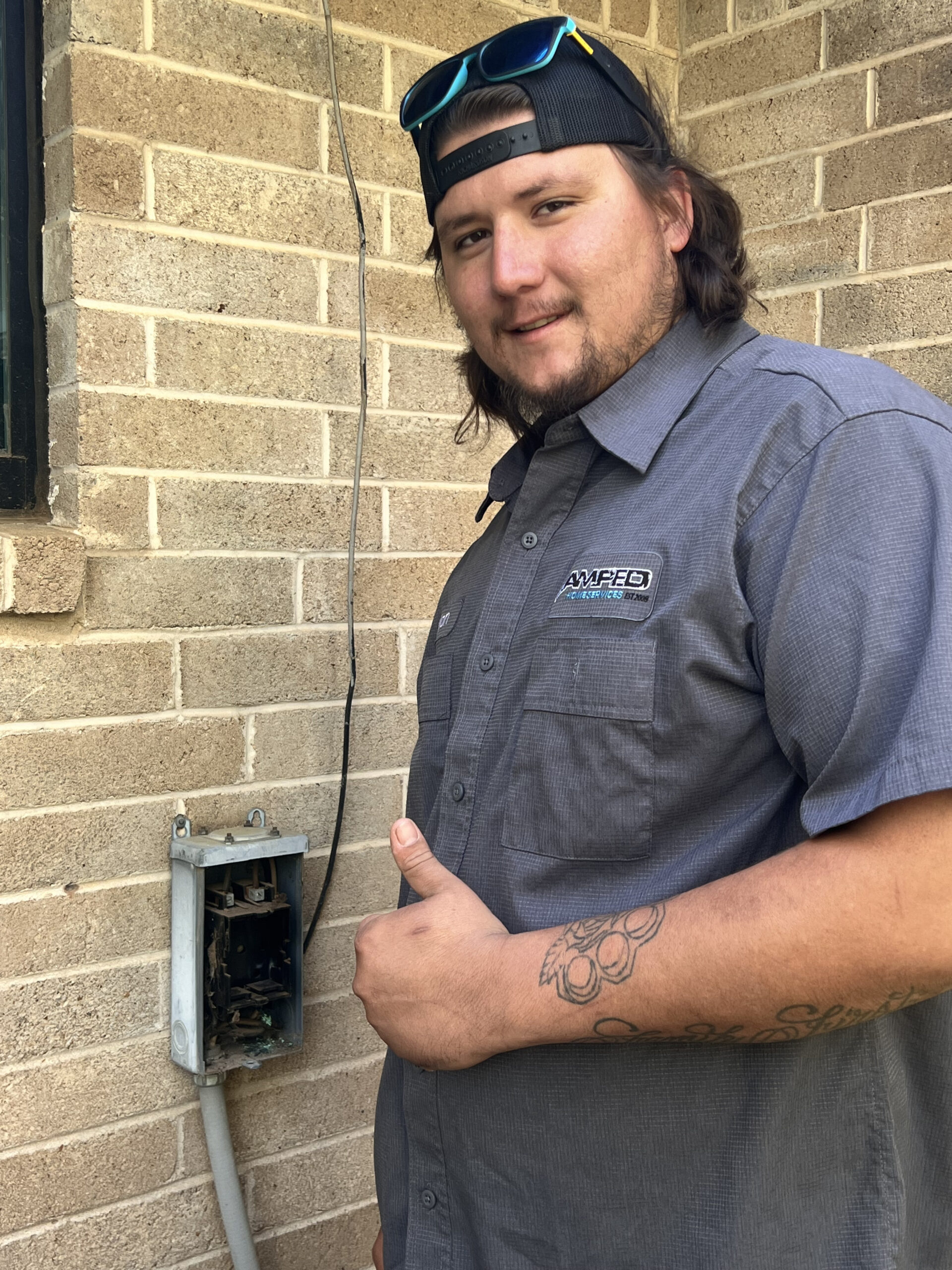Amped technician inspecting outdoor utility box in Oklahoma.