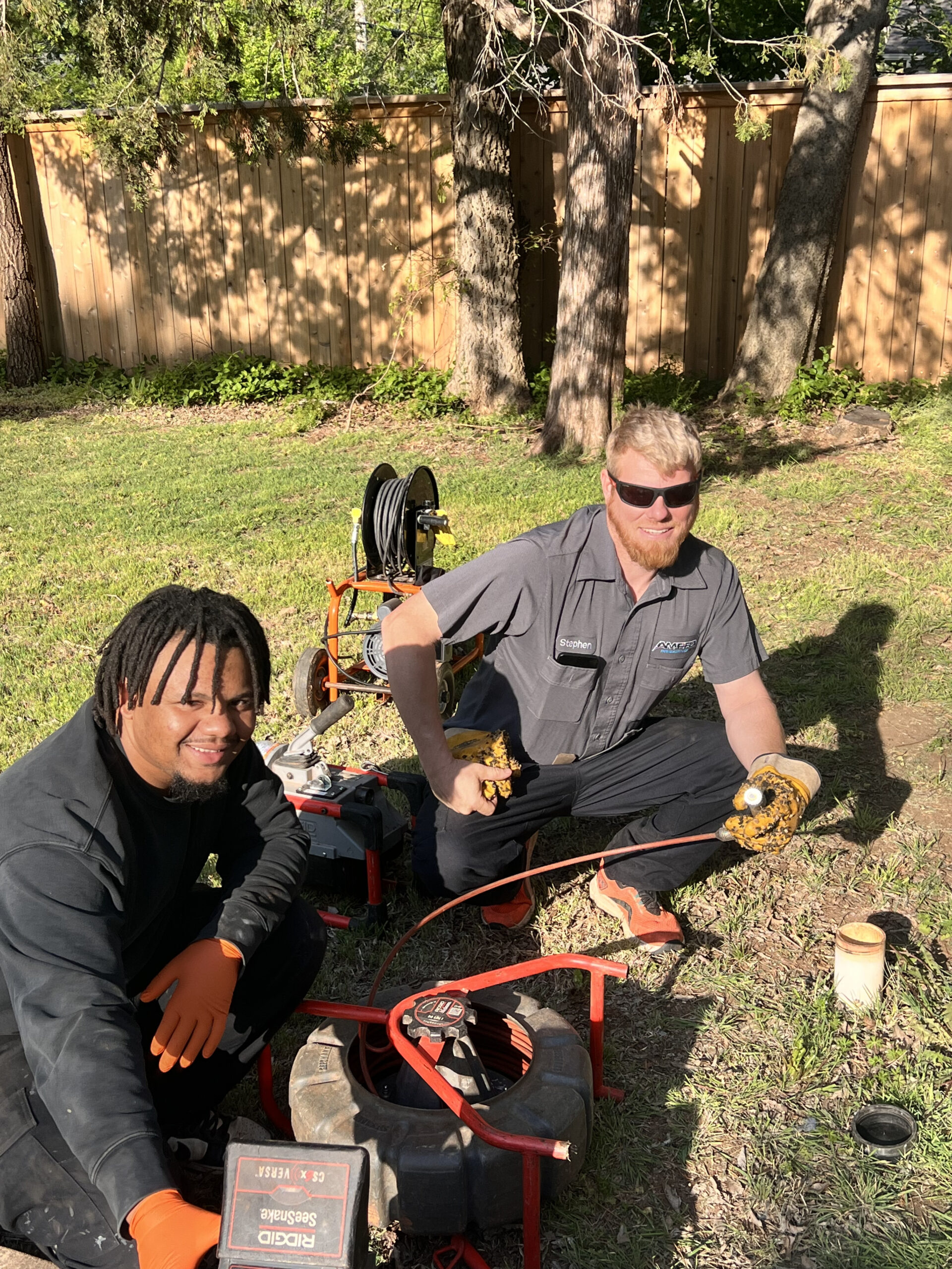 Amped plumbers preparing sewer cleaning equipment in Oklahoma.