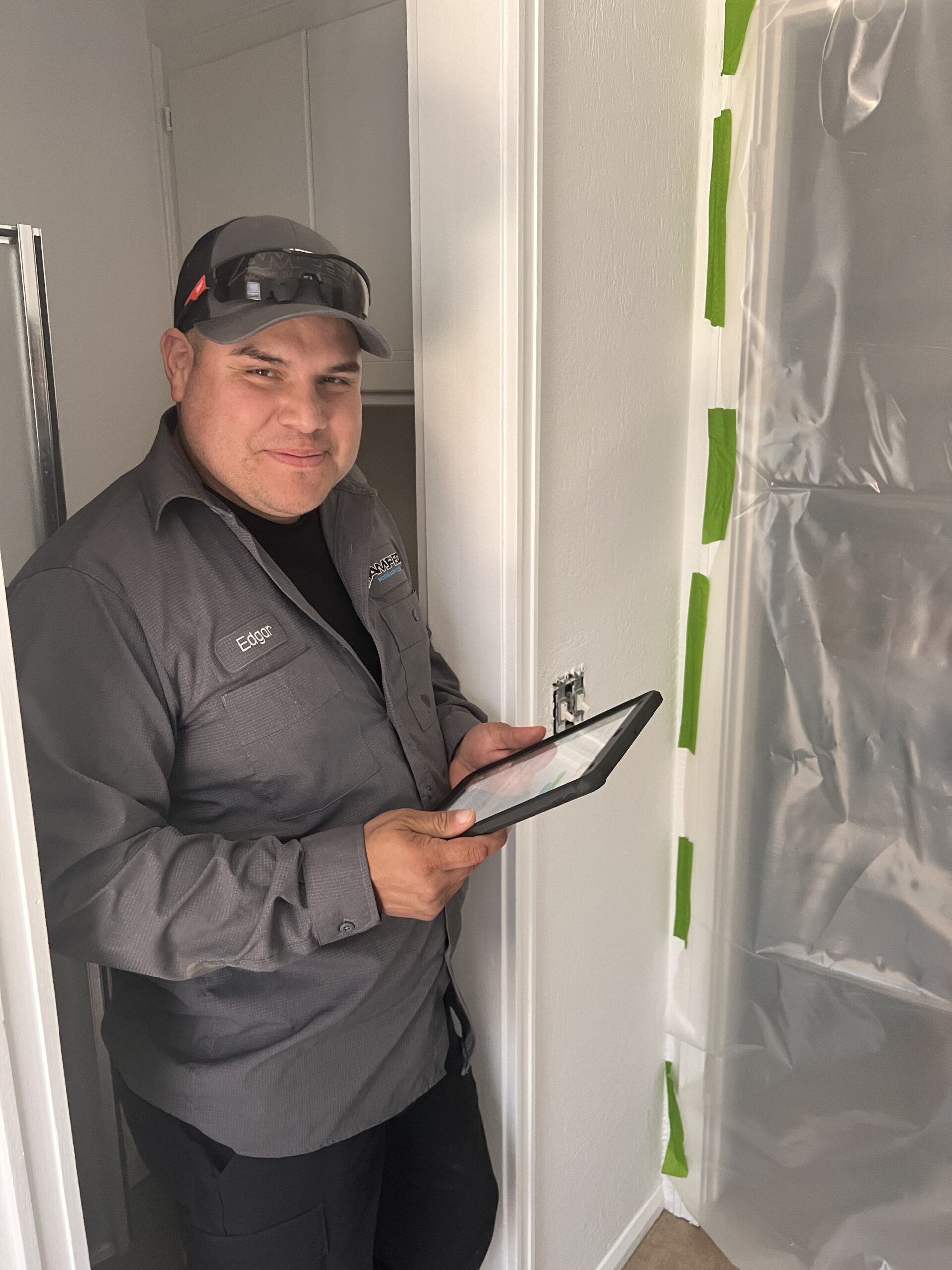 Amped technician using tablet for plumbing inspection in Oklahoma.