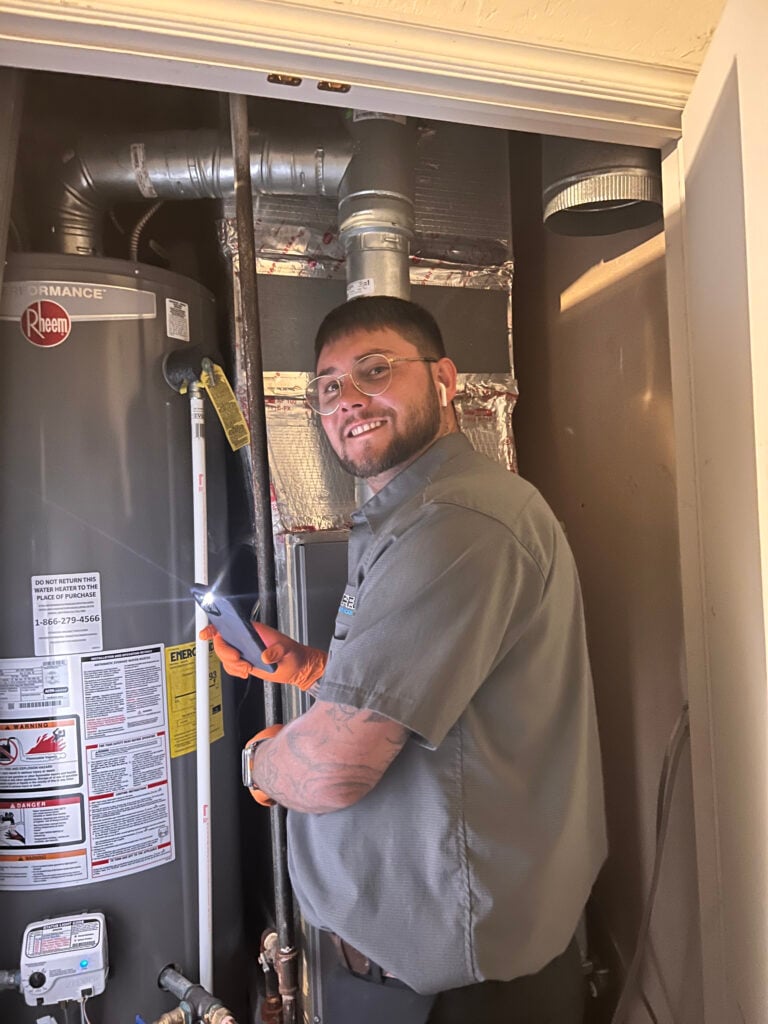 Amped plumber servicing gas water heater in Oklahoma.