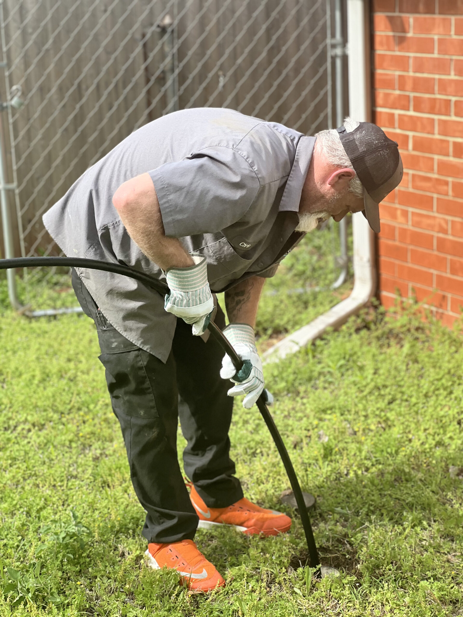 Amped plumber using drain snake for sewer line cleaning in Oklahoma.