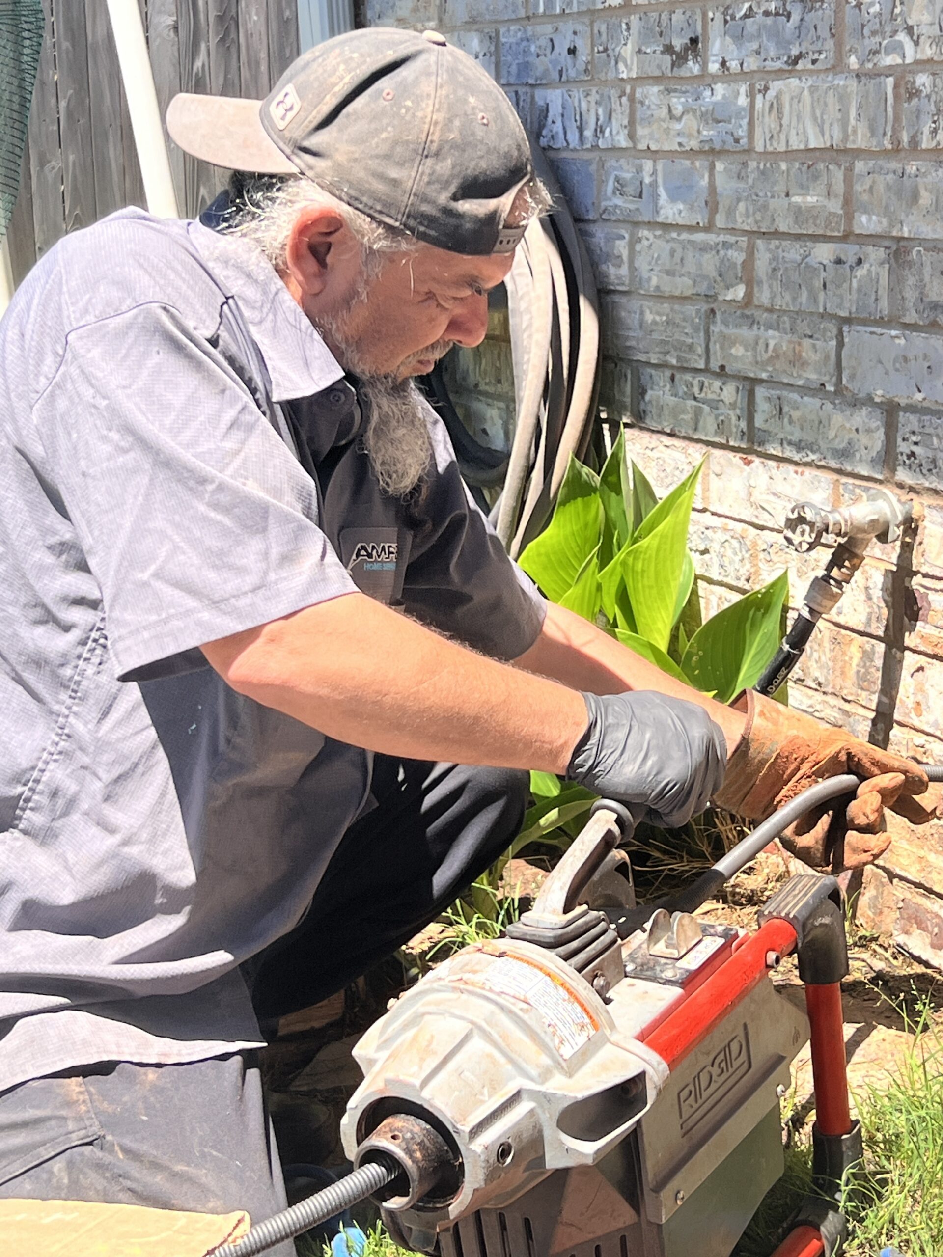 Amped plumber cleaning outdoor sewer line in Oklahoma.