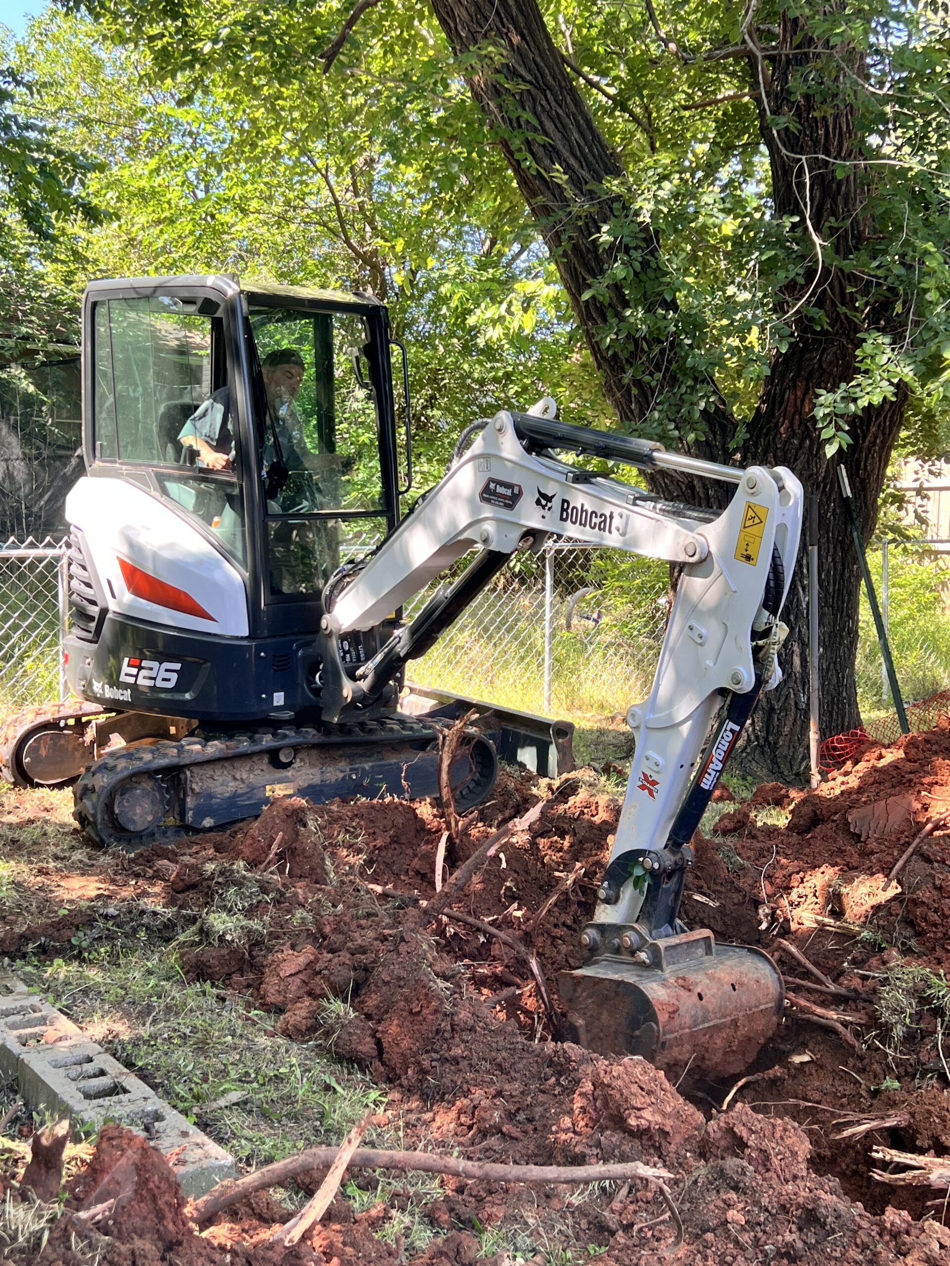 Amped technician operating mini excavator for trenching in Oklahoma.
