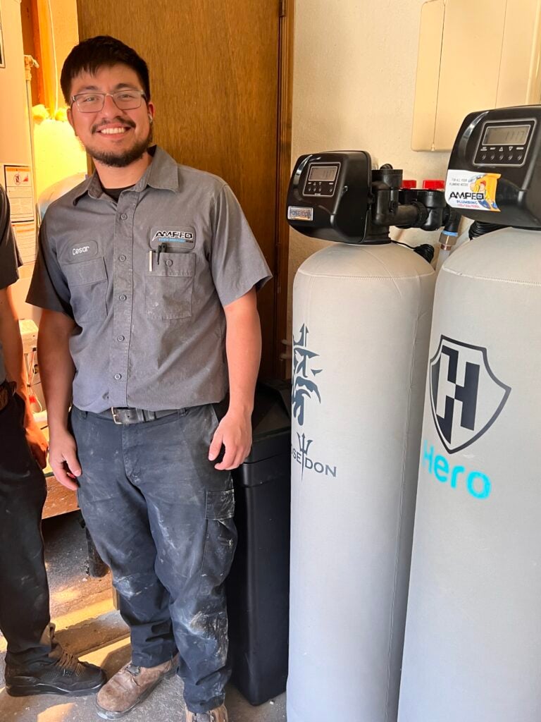 Amped plumber servicing home water filtration system in Oklahoma.