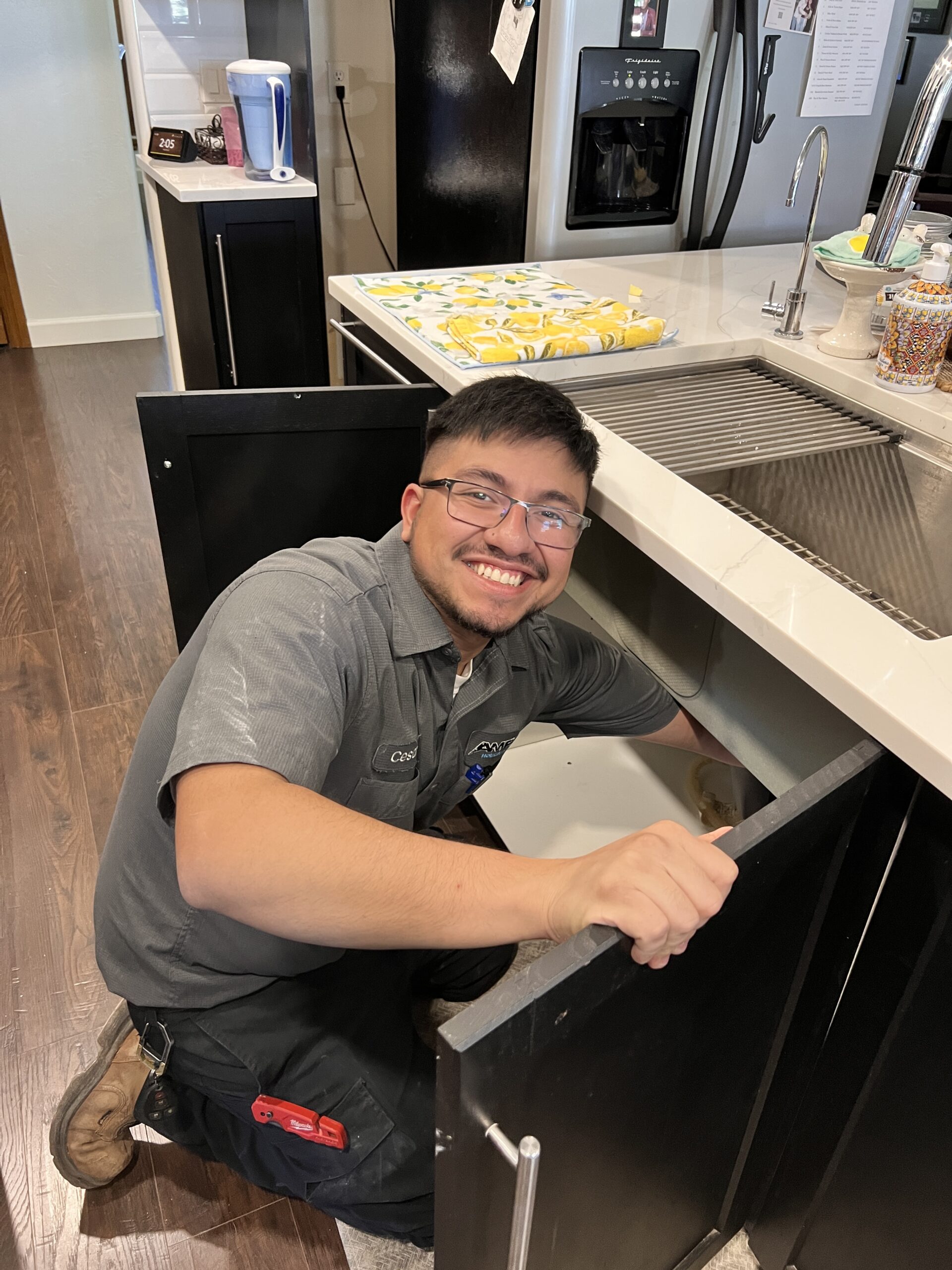 Amped plumber repairing kitchen sink plumbing in Oklahoma.