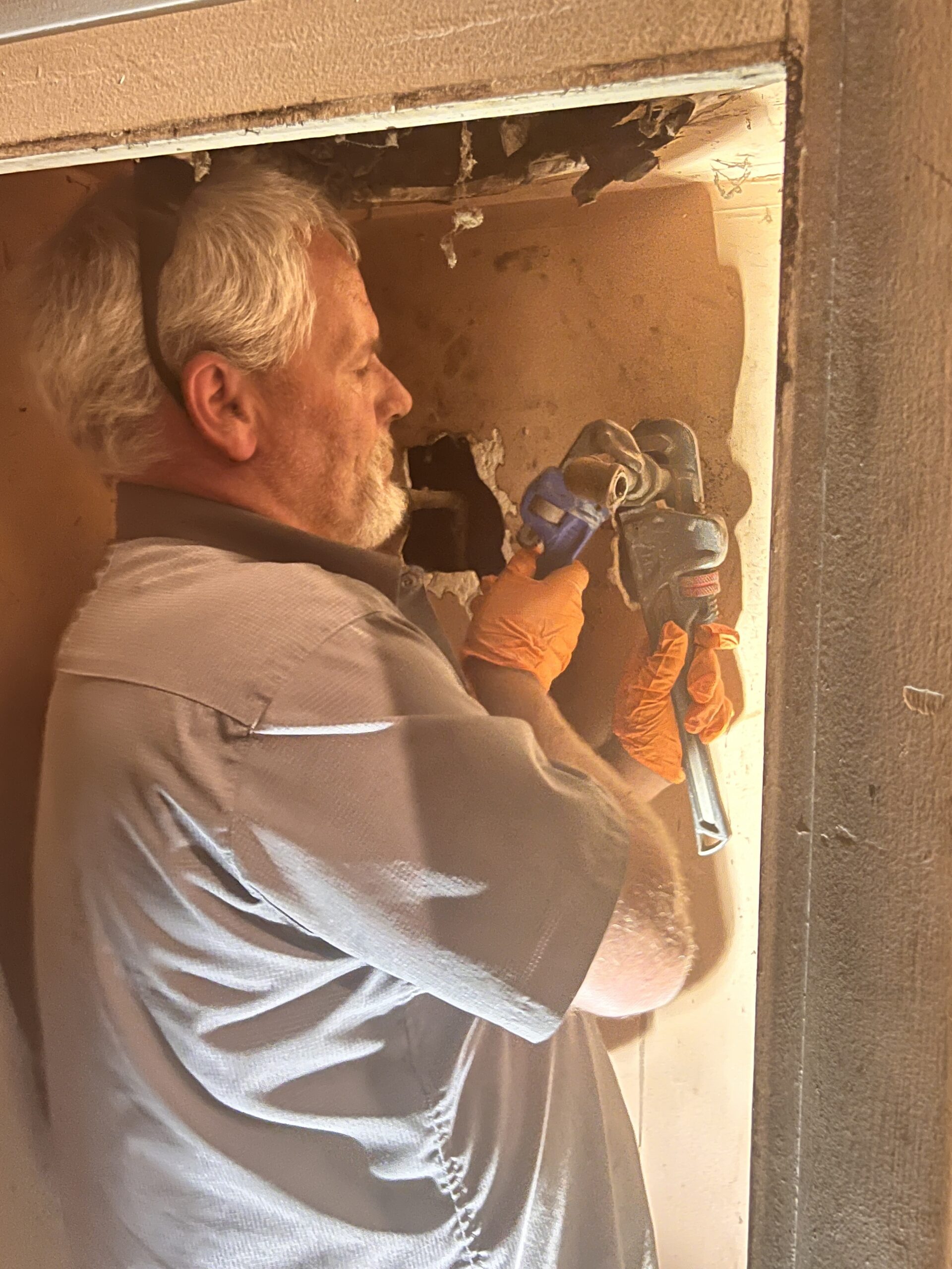 Amped plumber tightening pipe connections in Oklahoma.