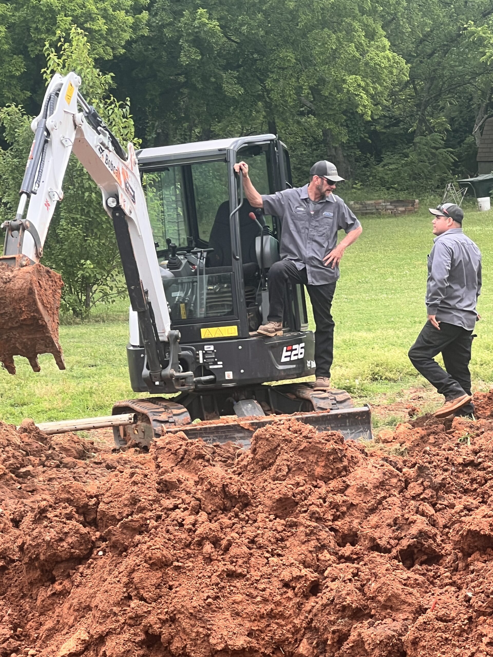 Amped crew using excavator for outdoor plumbing project in Oklahoma.