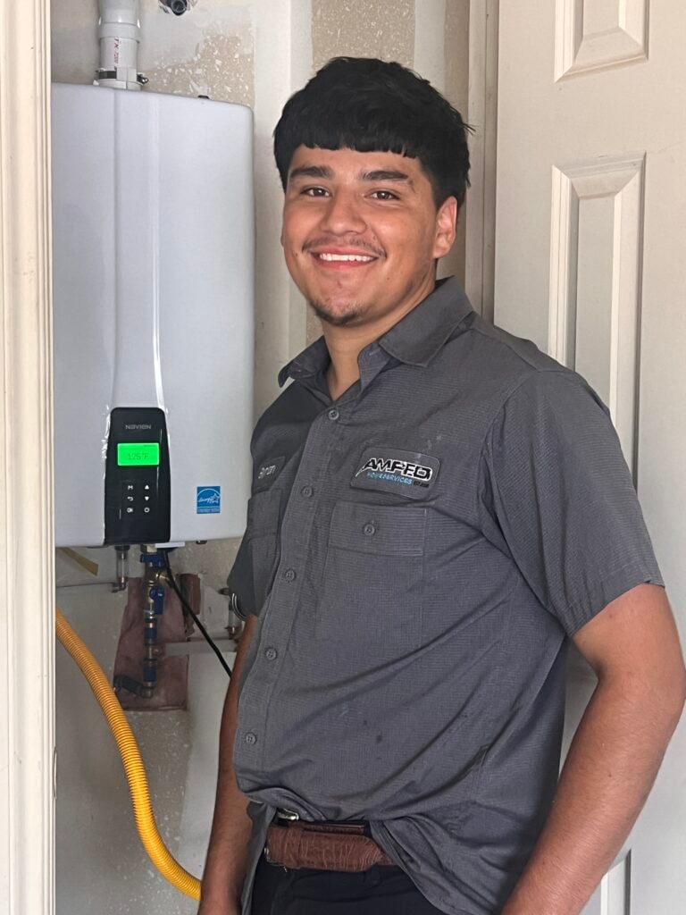 Amped plumber servicing tankless water heater in Oklahoma.