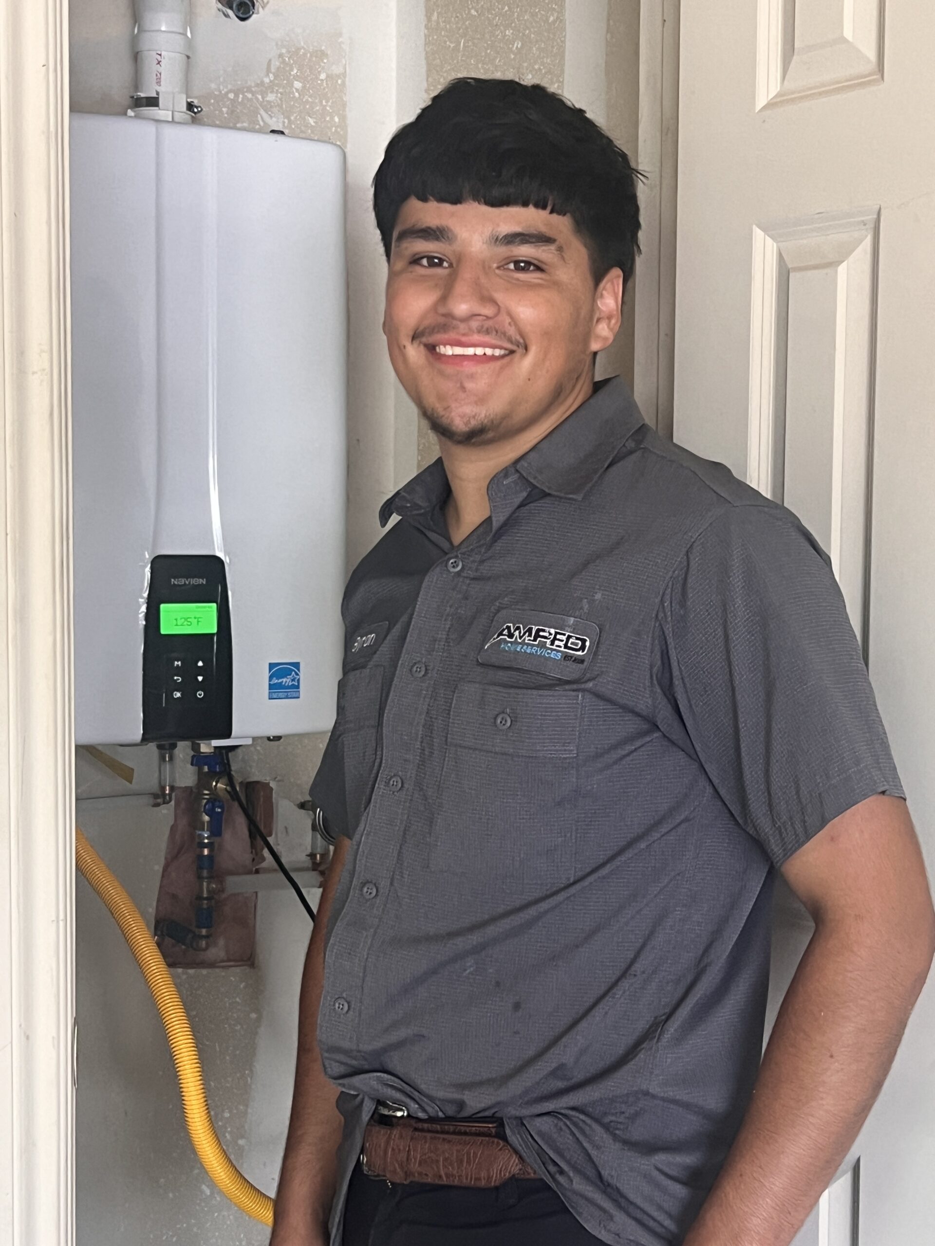 Amped plumber servicing tankless water heater in Oklahoma.