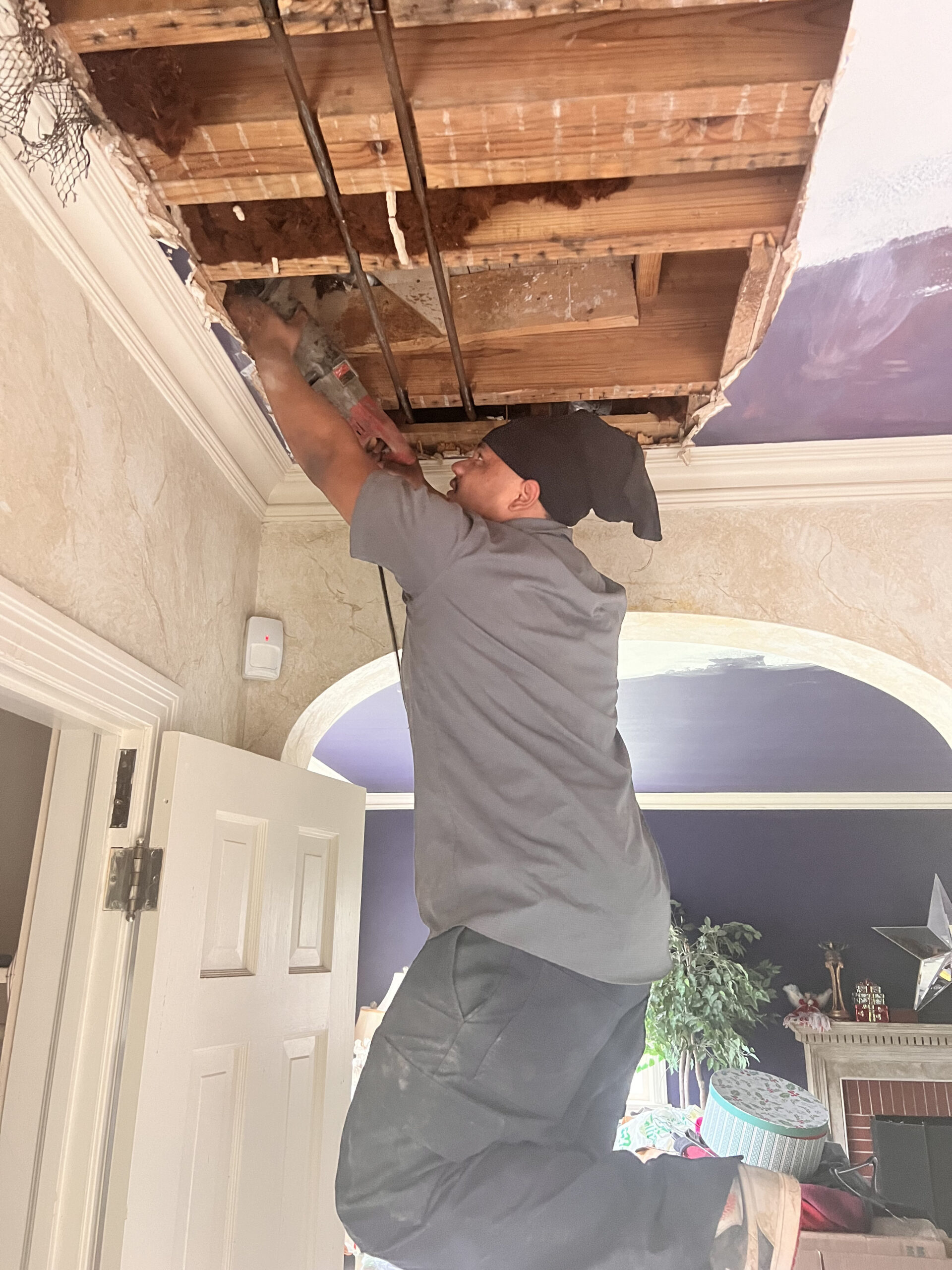 Amped plumber performing overhead pipe repair in Oklahoma.