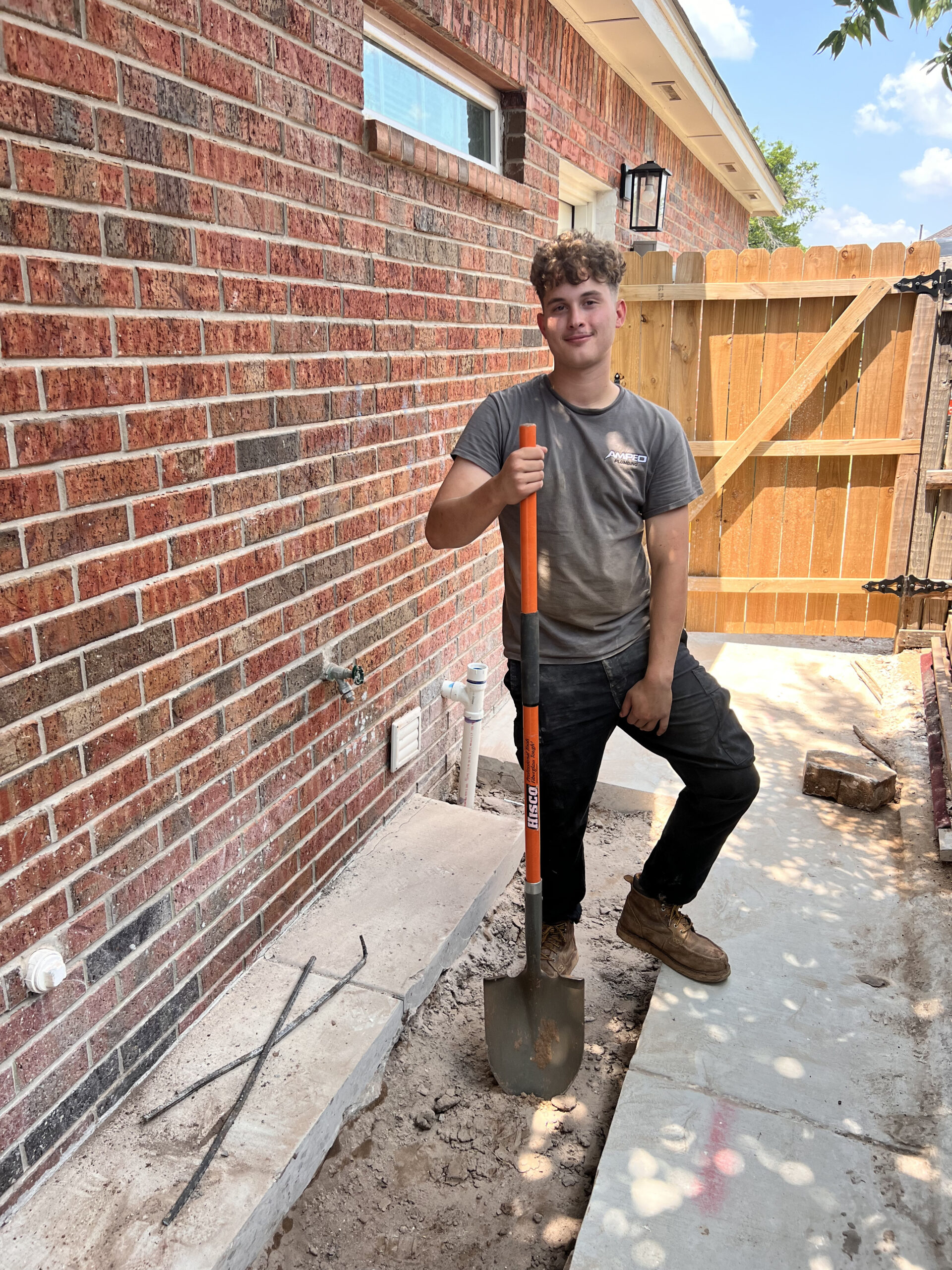 Amped plumber preparing for outdoor plumbing work in Oklahoma.