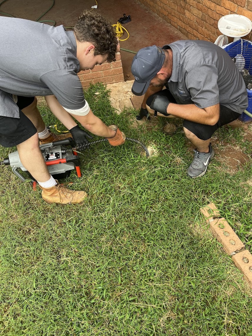 Amped plumbers inspecting underground water line in Oklahoma.