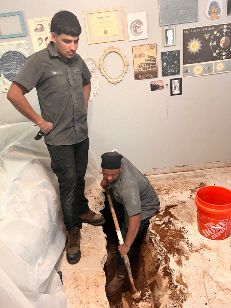 Amped plumbers digging indoor floor for plumbing repair in Oklahoma.