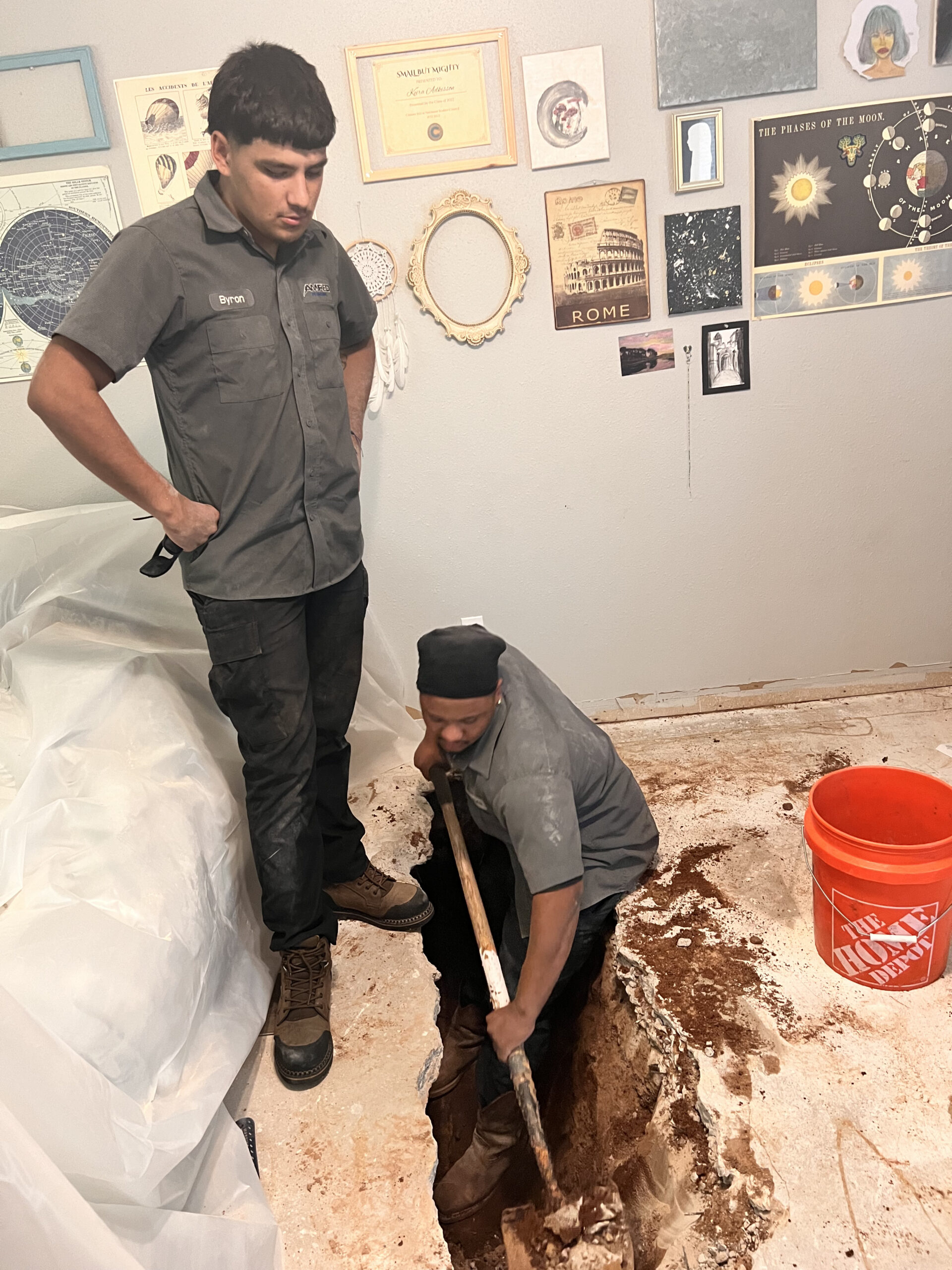 Amped plumbers digging indoor floor for plumbing repair in Oklahoma.