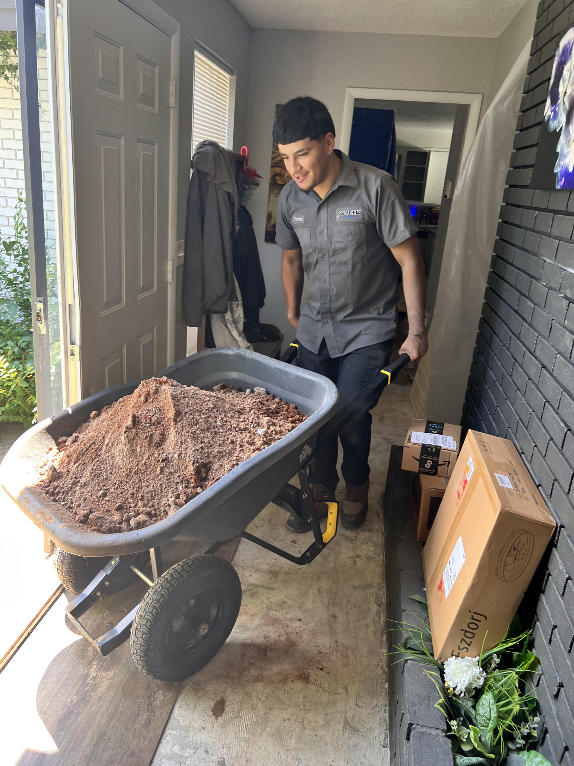 Amped plumber transporting soil from indoor excavation in Oklahoma.