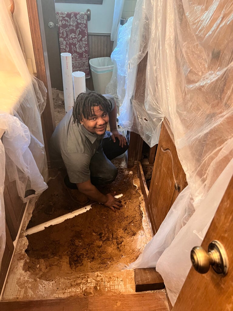 Amped plumber digging inside home to reach underground plumbing in Oklahoma.