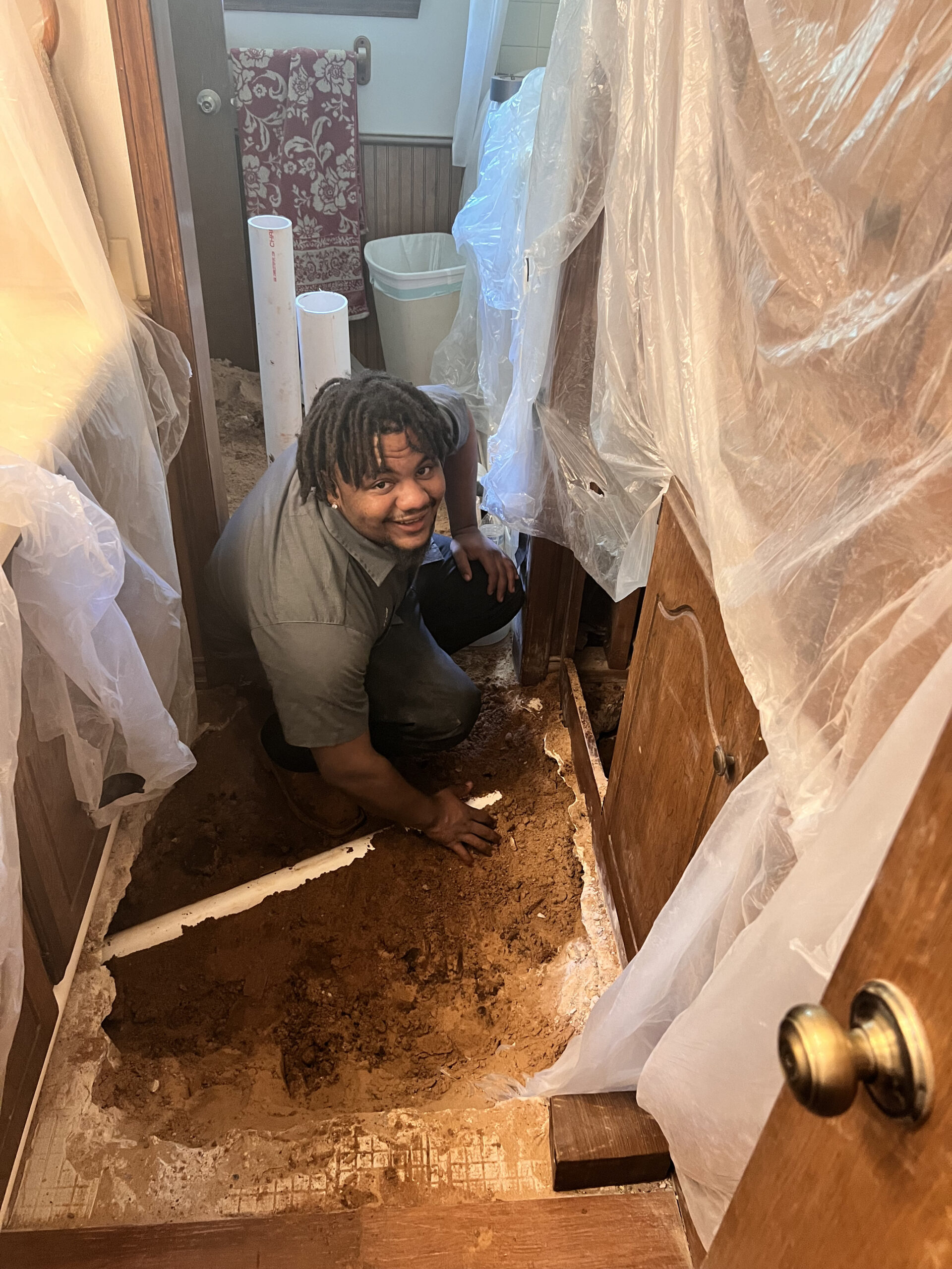 Amped plumber digging inside home to reach underground plumbing in Oklahoma.
