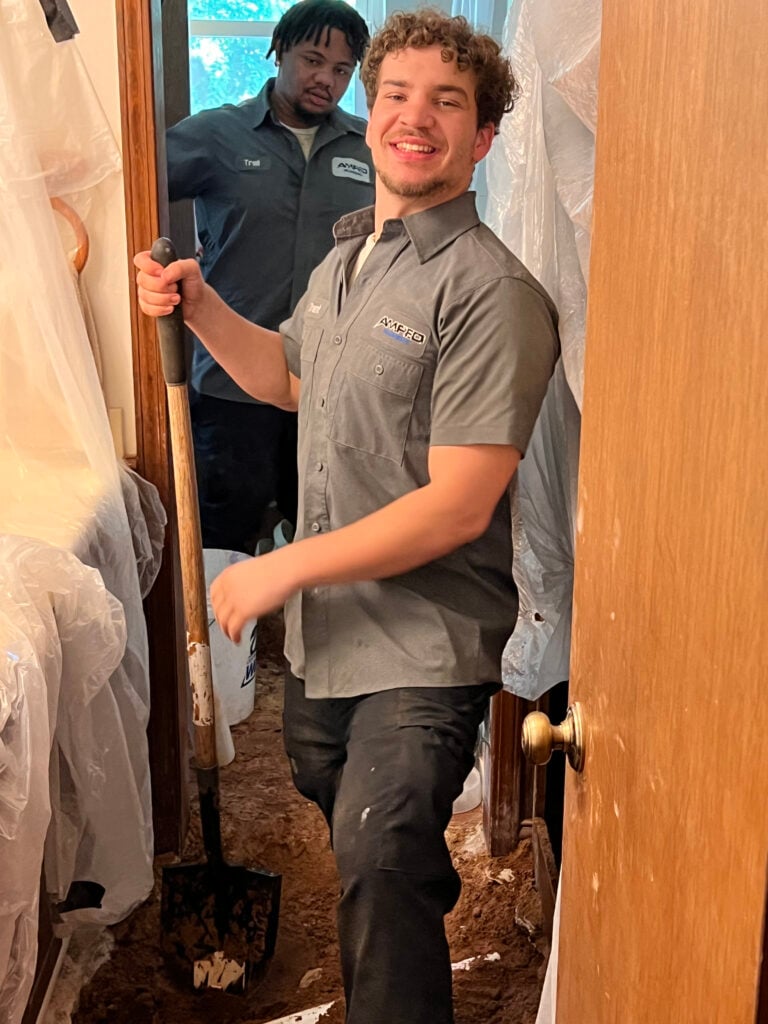 Amped plumber digging for plumbing repair inside Oklahoma home.