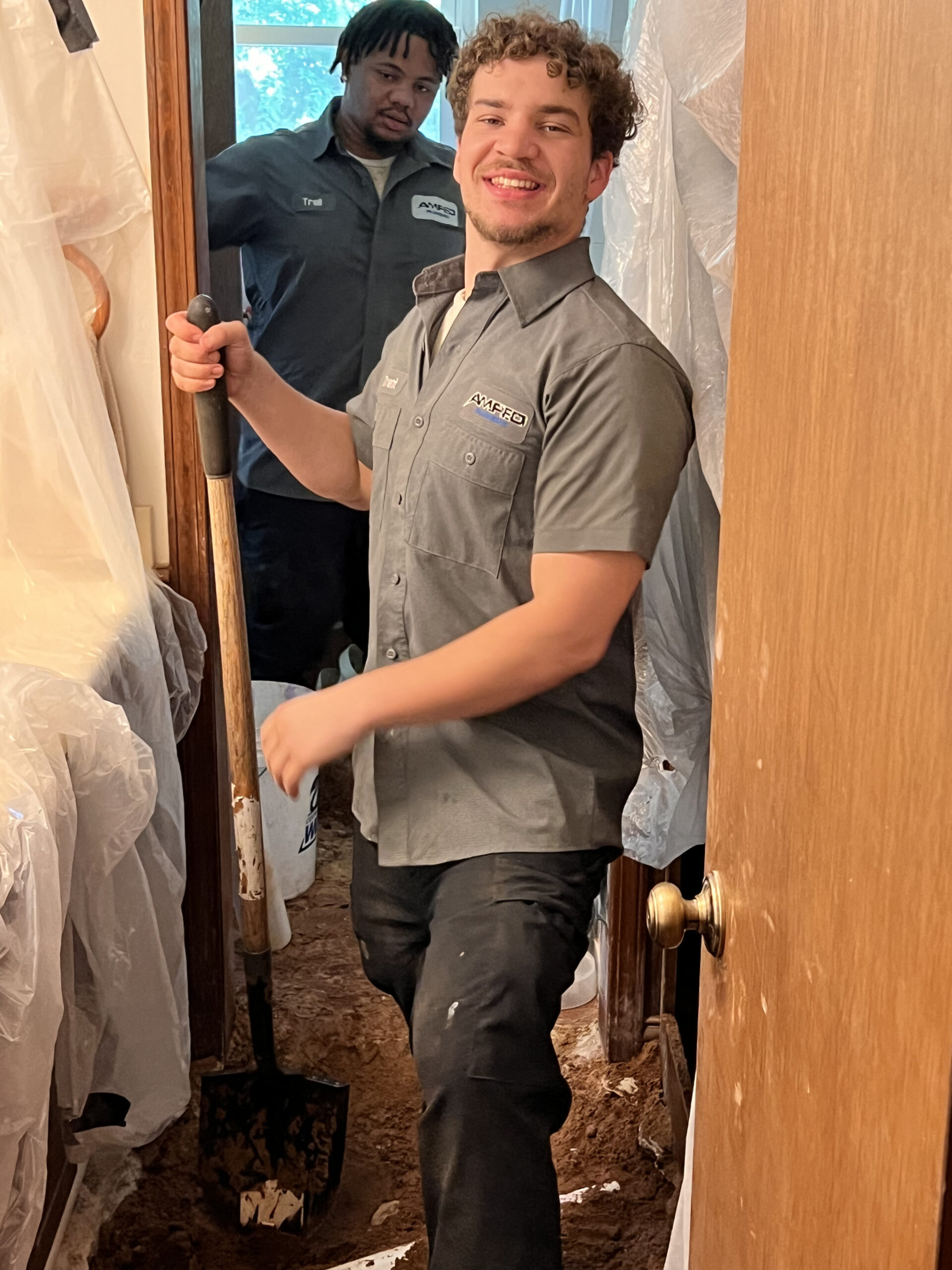 Amped plumber digging for plumbing repair inside Oklahoma home.