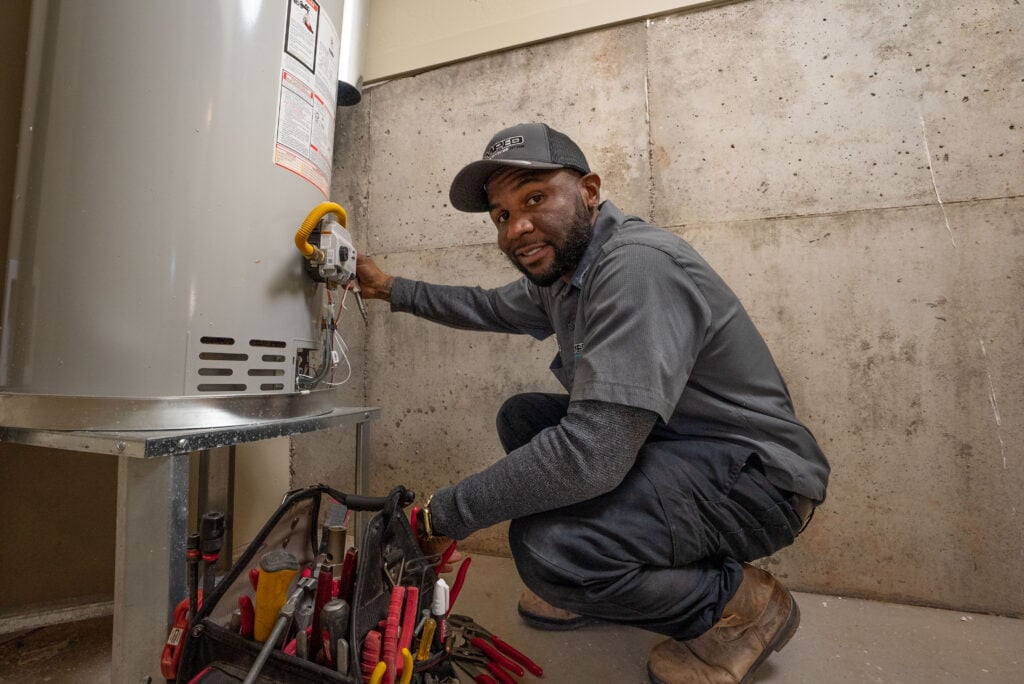 Amped technician installing or servicing a tankless water heater.