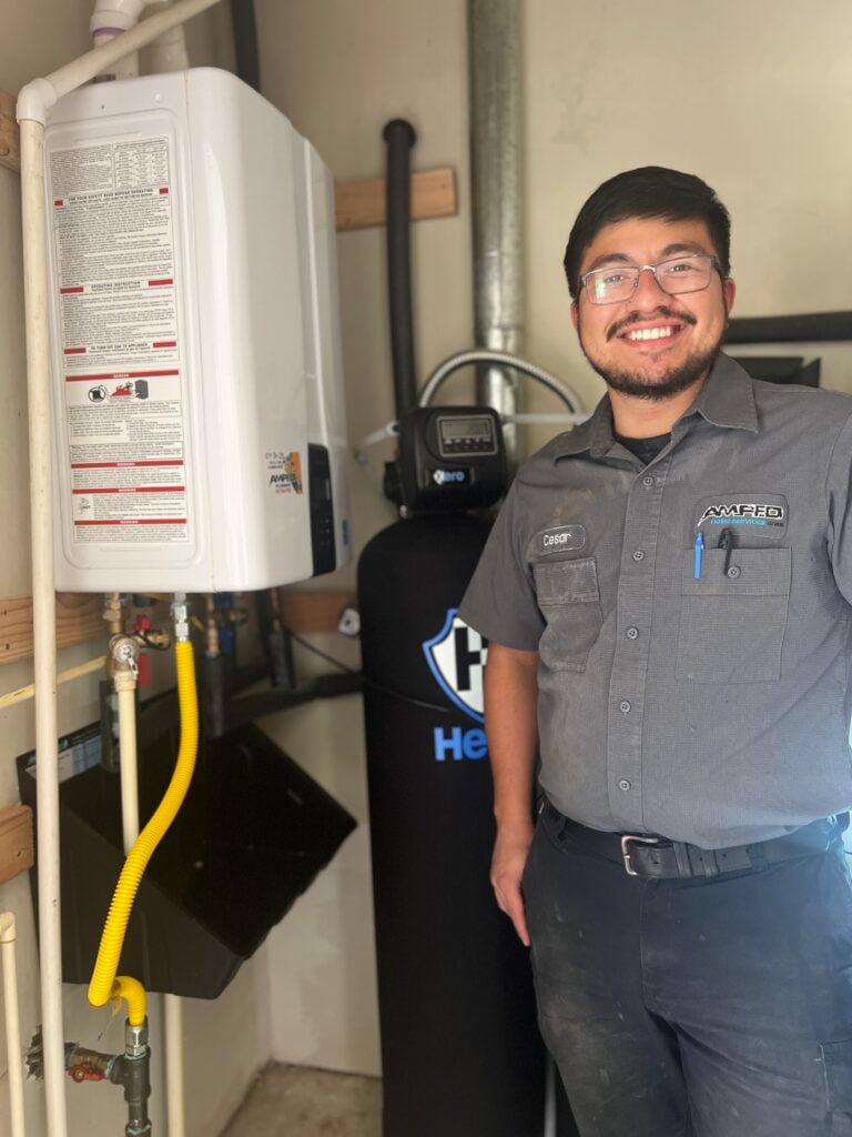 Amped technician next to a water filtration system.