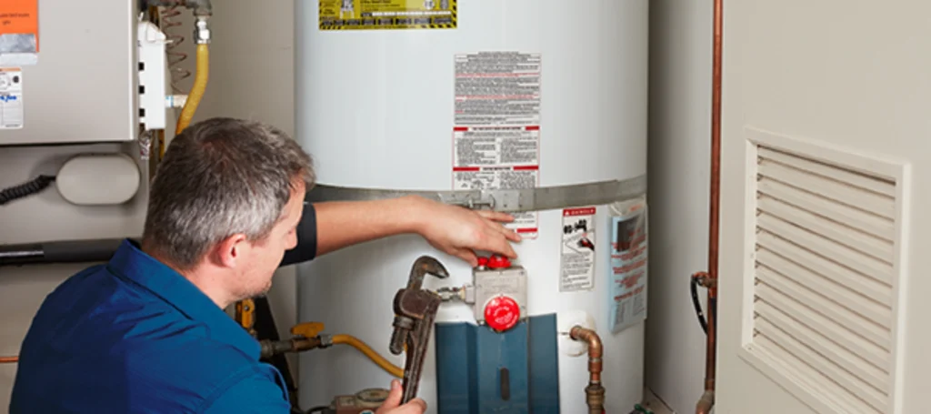 Technician servicing controls on a commercial tank water heater