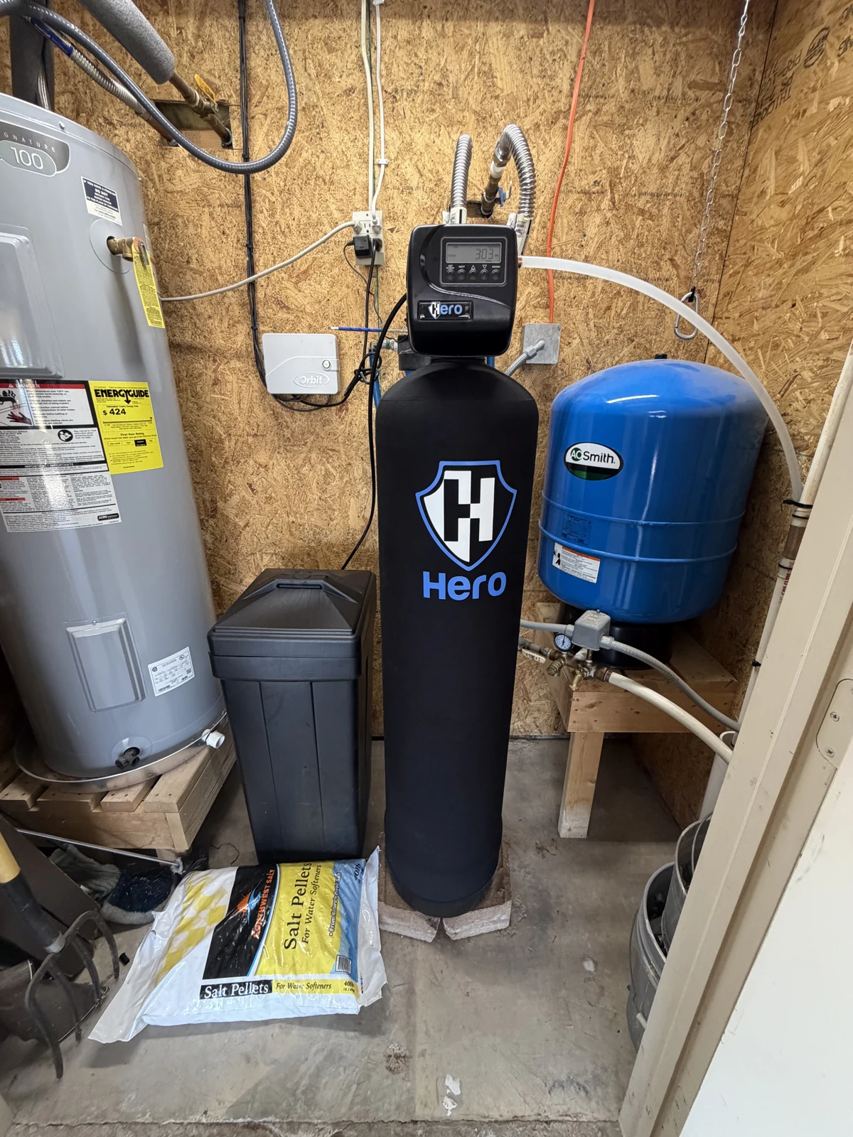 HERO water softener with a black brine tank beside a water heater