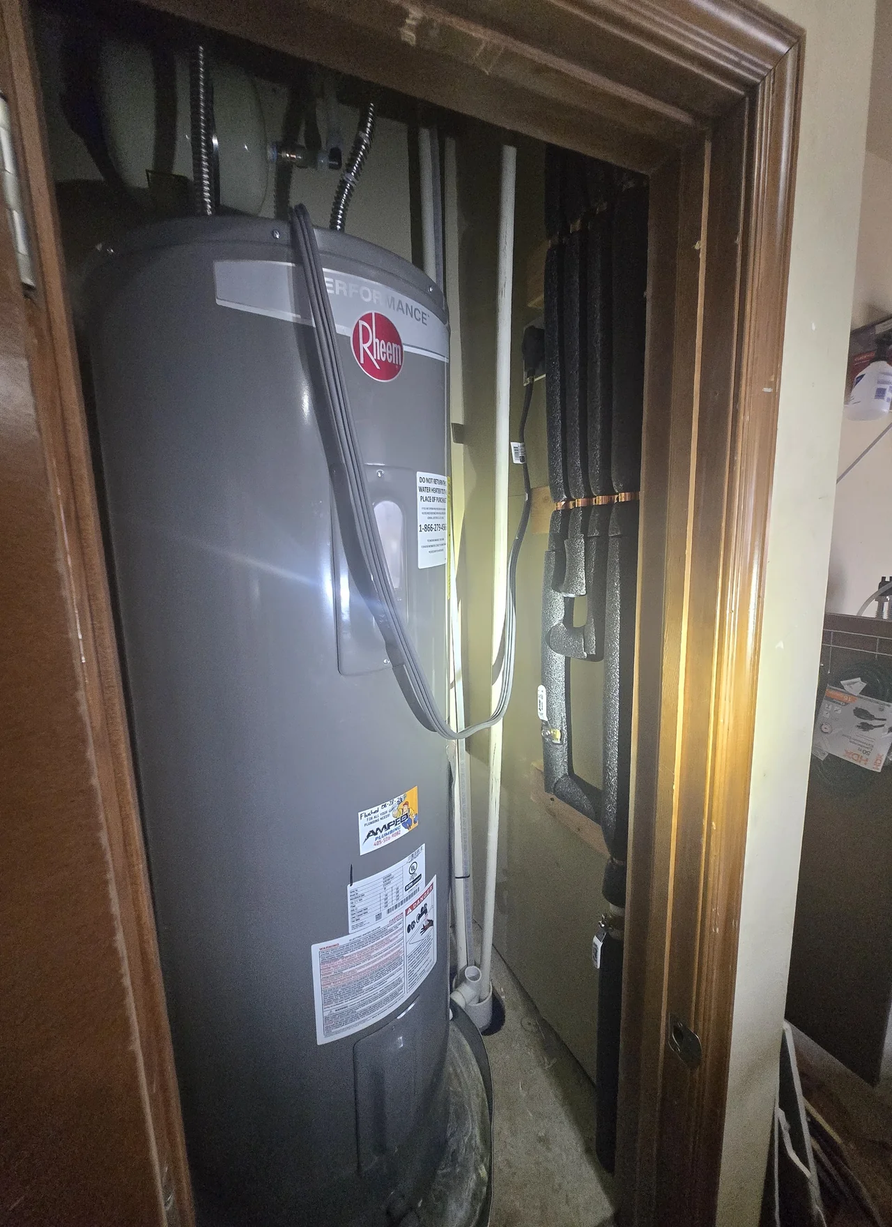 Rheem tank water heater installed in a closet with insulated piping